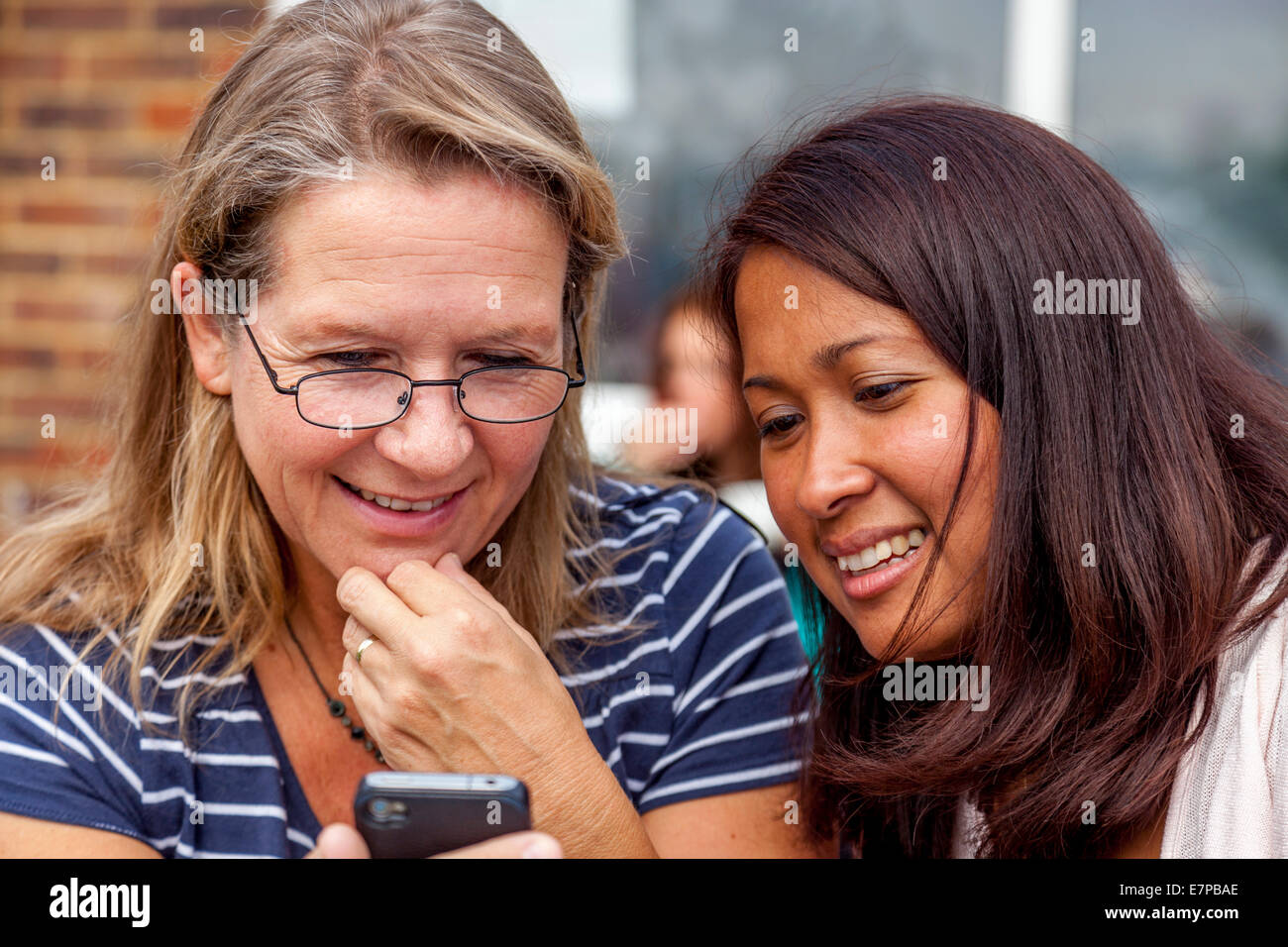 Deux femmes à la recherche de photographies sur un Smartphone, Hartfield Fête du Village, Sussex, Angleterre Banque D'Images