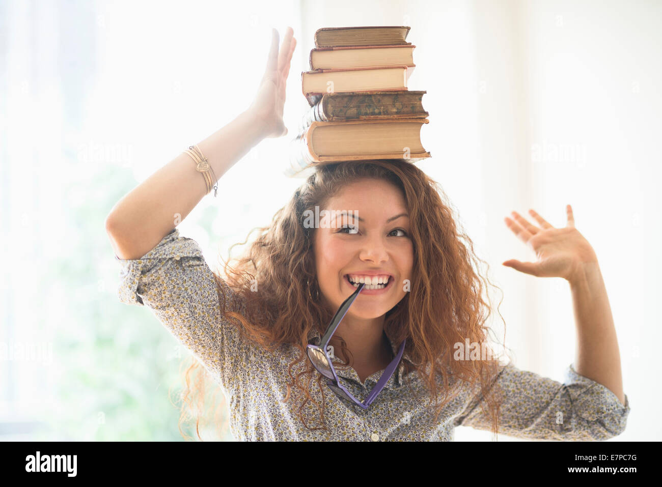Portrait de femme avec des livres sur le dessus de la tête Banque D'Images