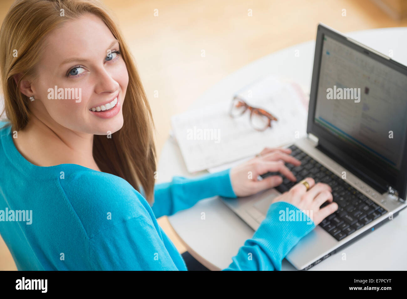 Smiling young woman using laptop Banque D'Images