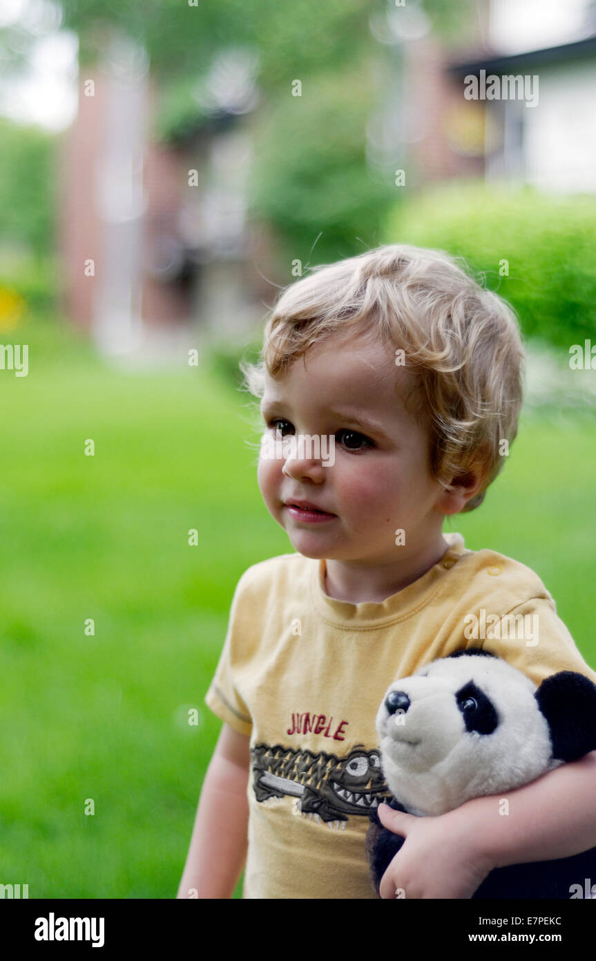 Portrait d'un petit garçon portant un panda jouet Banque D'Images