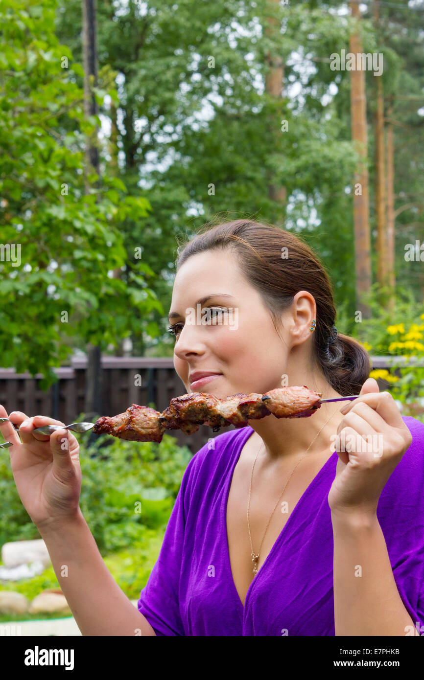 Woman enjoying barbecue en plein air Banque D'Images