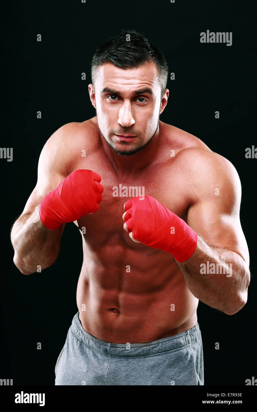Portrait of muscular male boxer dans la position sur fond noir Banque D'Images