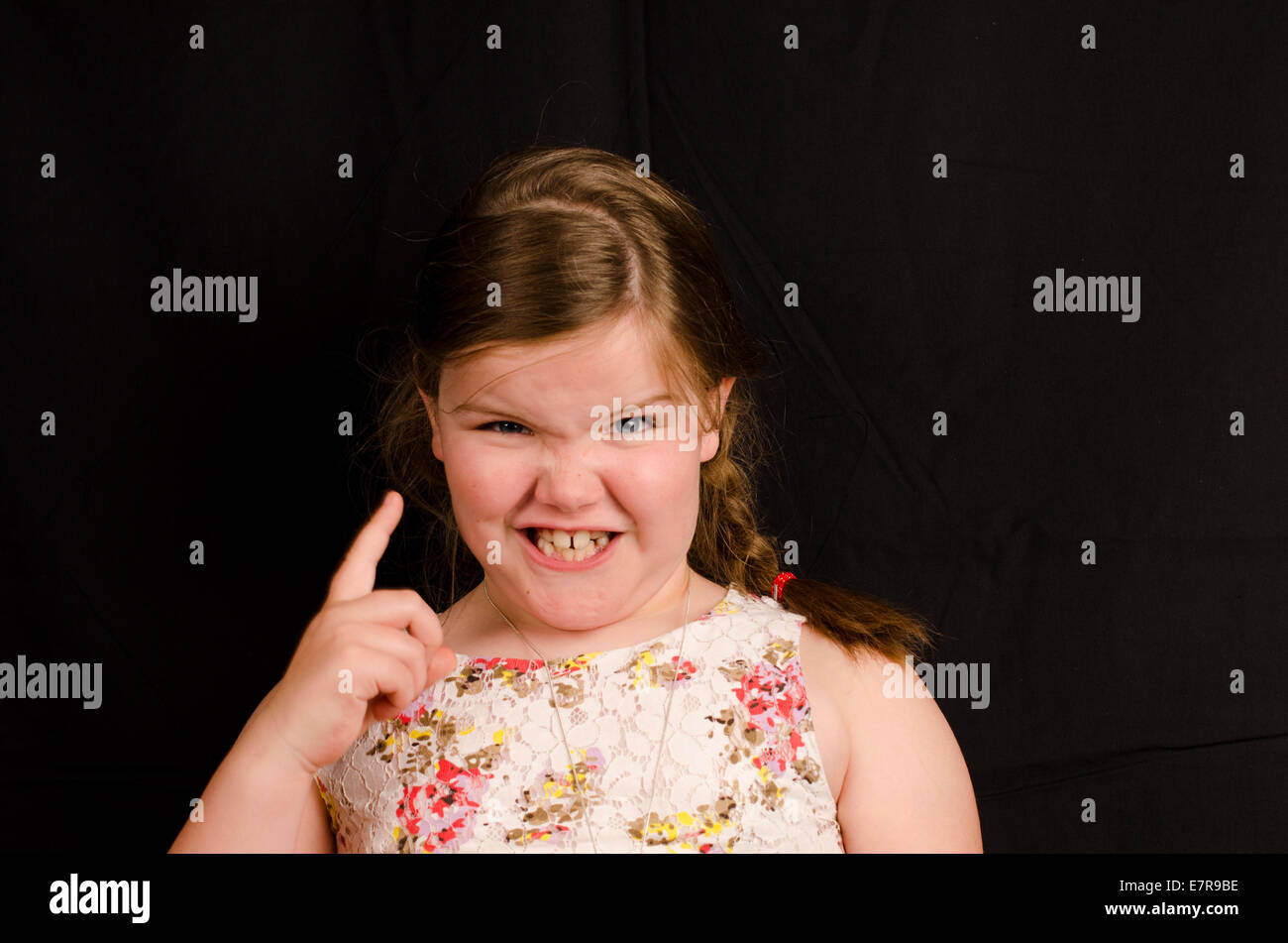 Image d'une fillette de 8 ans sur un fond noir avec une expression Banque D'Images