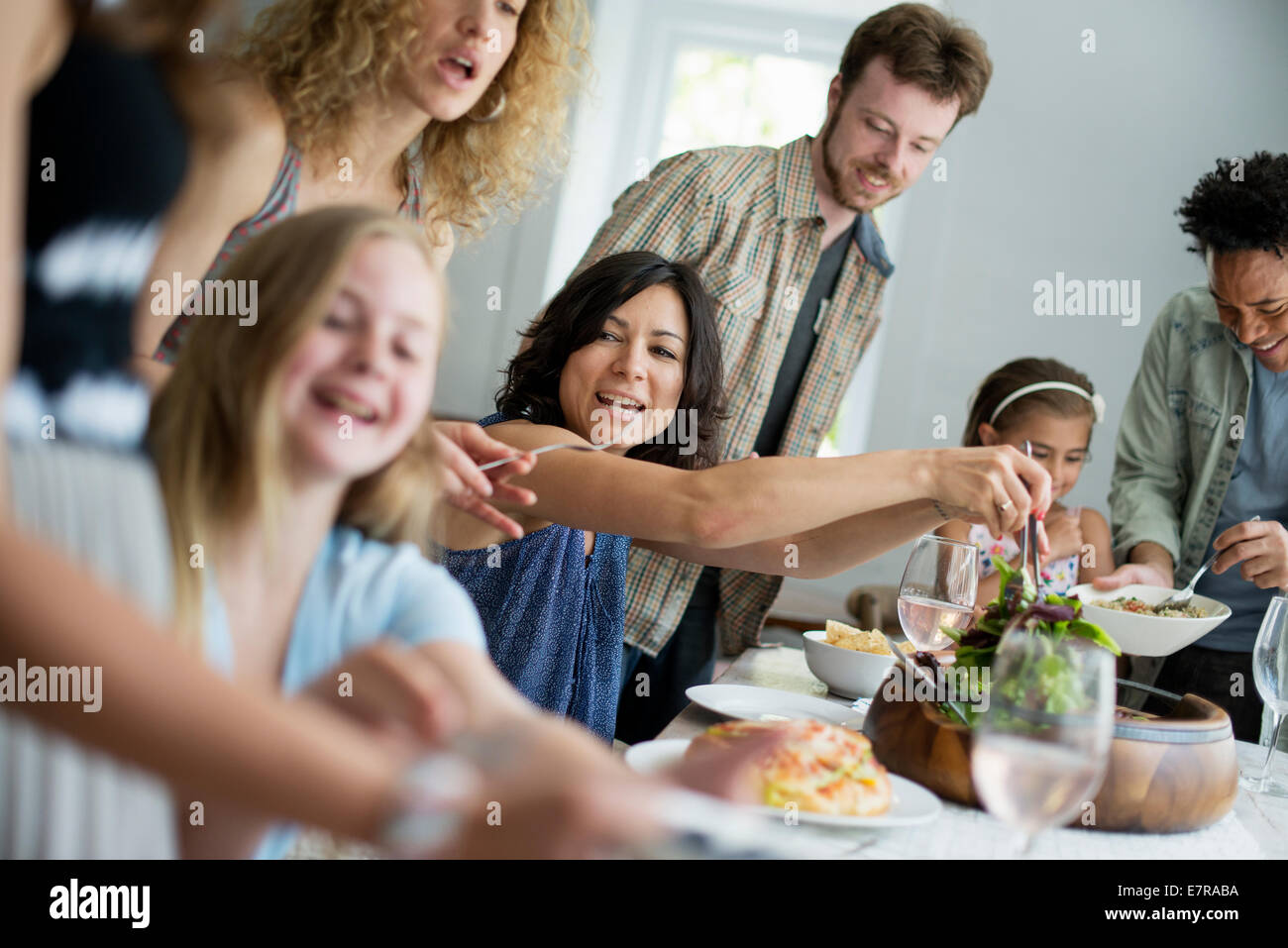 Une réunion de famille pour un repas. Les adultes et les enfants autour d'une table. Banque D'Images