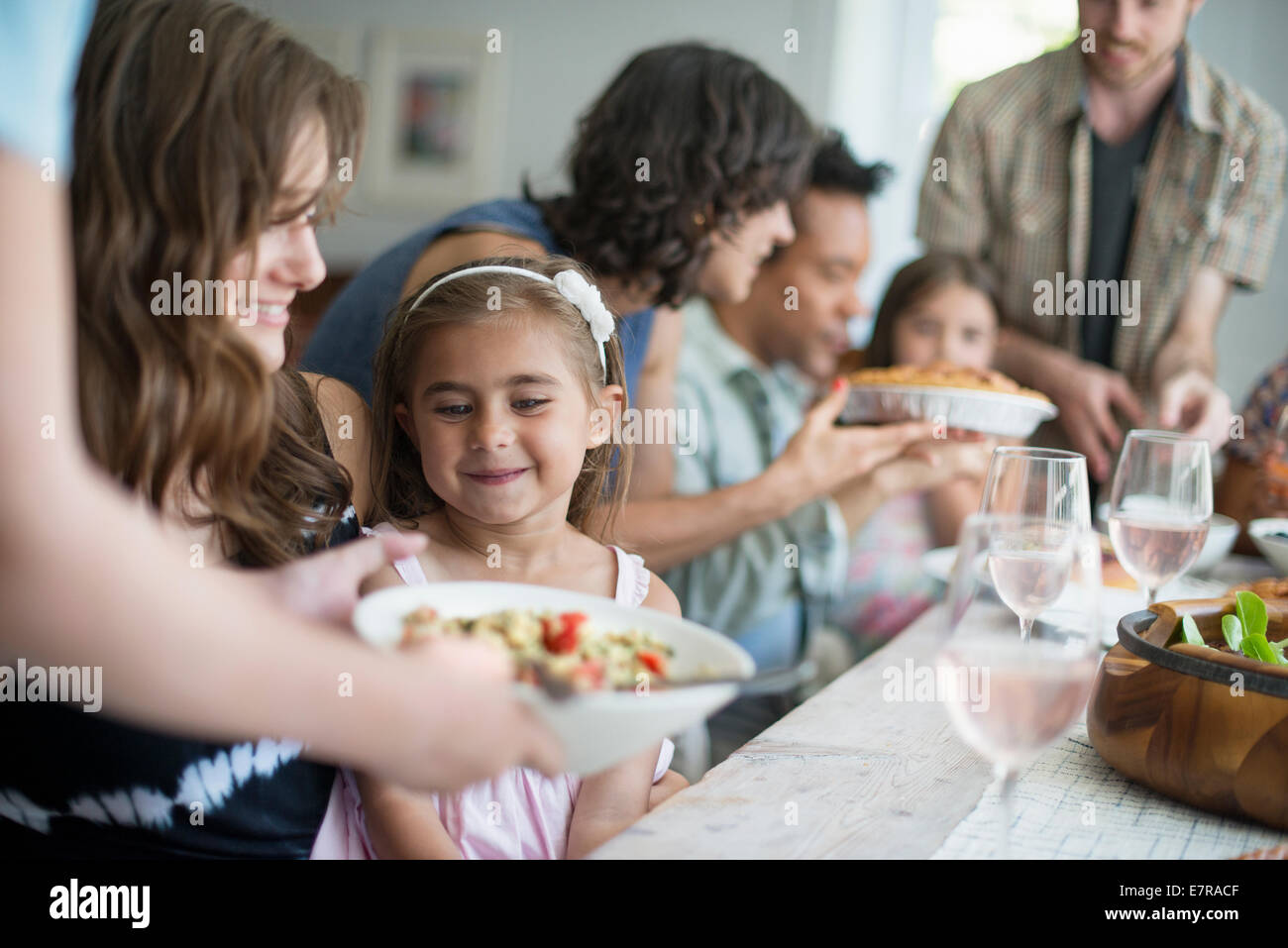 Une réunion de famille pour un repas. Les adultes et les enfants autour d'une table. Banque D'Images