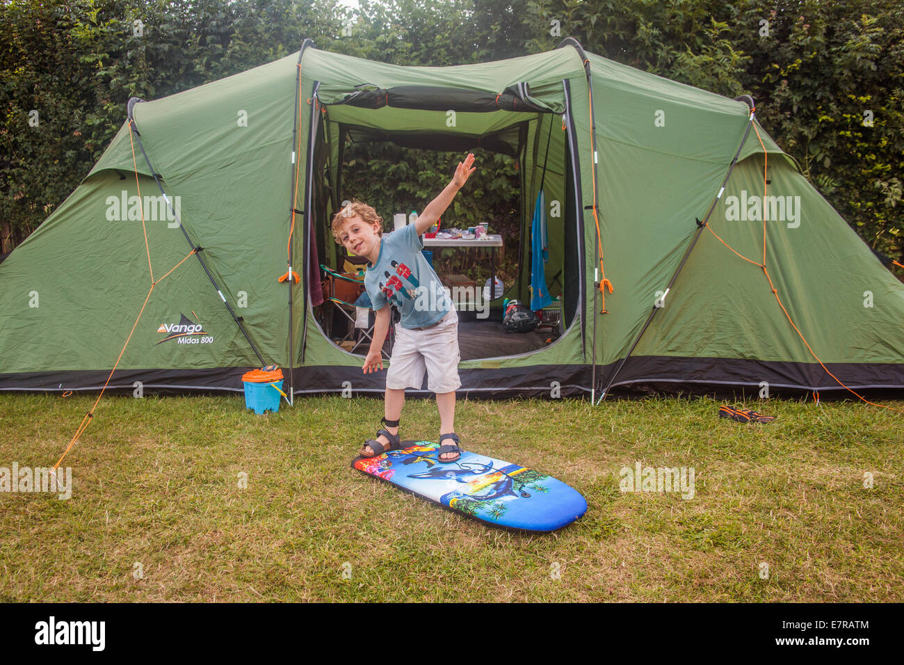 À l'âge de cinq ans, garçon jouant sur une planche de surf au camping Karrageen Bolberry, près de Hope Cove, South Devon, Angleterre, Royaume-Uni. Banque D'Images