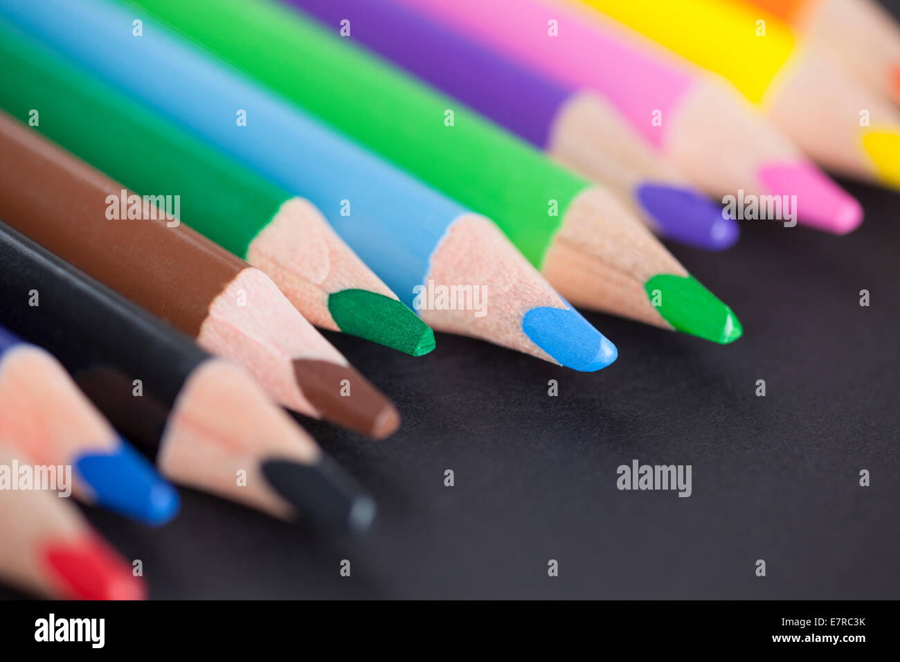 Crayons de couleur sur un fond noir. Close-up. Banque D'Images