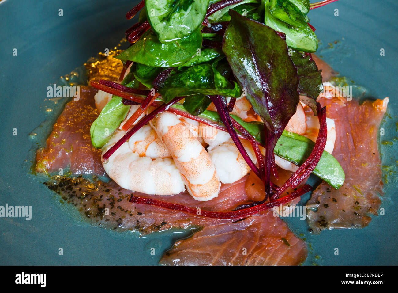 Salade de crevettes et saumon fumé avec des feuilles de betterave et dressing Banque D'Images