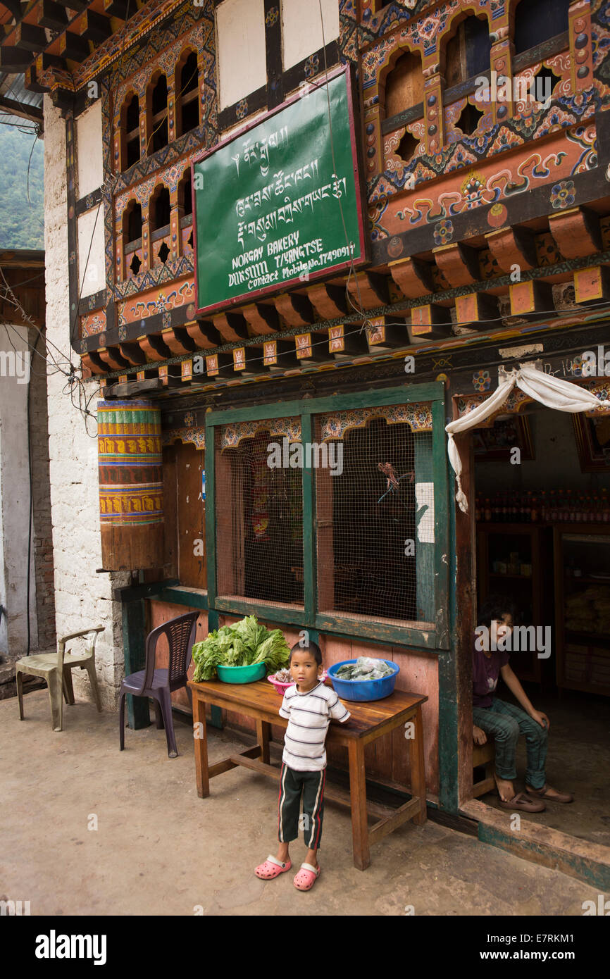 L'est du Bhoutan, Trashigang, Duksum, bazar, l'enfant à l'extérieur Norgay Bakery Banque D'Images