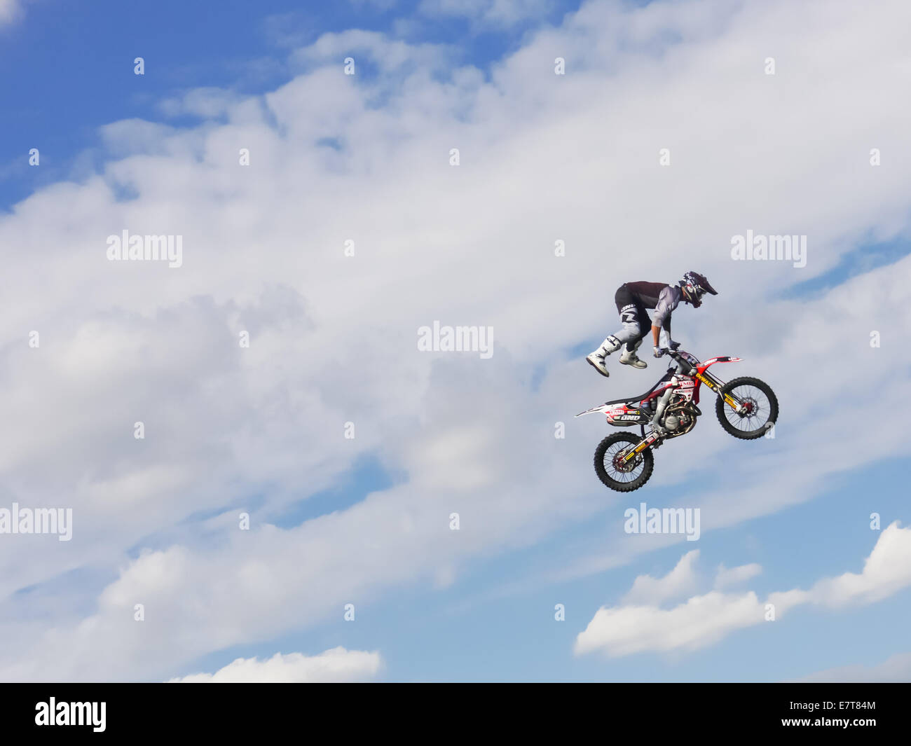 Une Fmx bike rider jumping contre un ciel bleu avec des nuages Banque D'Images