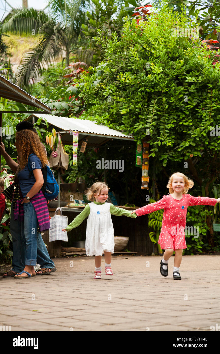 Une fillette de deux ans 2 / enfant / bébé / enfant et ses quatre 4 ans soeur de marche / jouer à l'intérieur de l'Eden Project biomes. UK. Banque D'Images