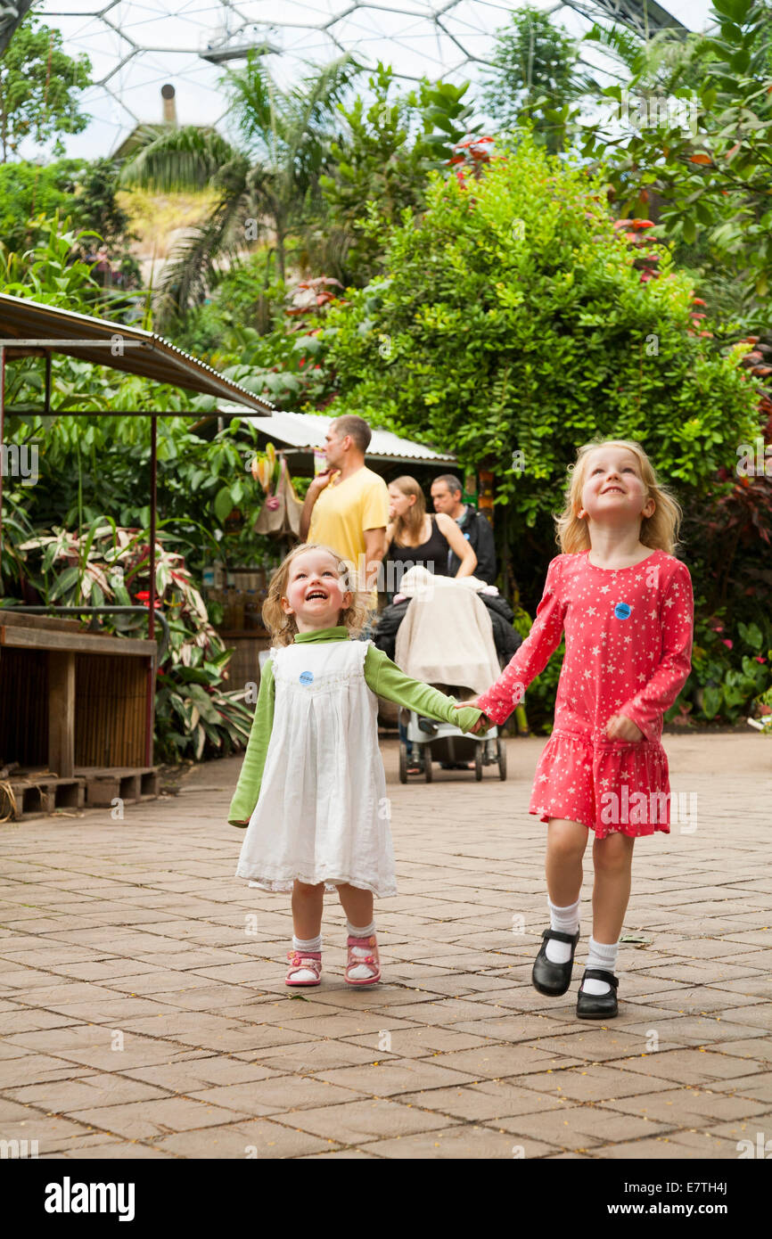 Une fillette de deux ans 2 / enfant / bébé / enfant et ses quatre 4 ans soeur de marche / jouer à l'intérieur de l'Eden Project biomes. UK. Banque D'Images