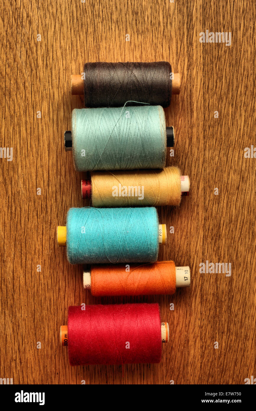 De nombreux rouleaux de coton de couleur sur un fond de bois. Banque D'Images