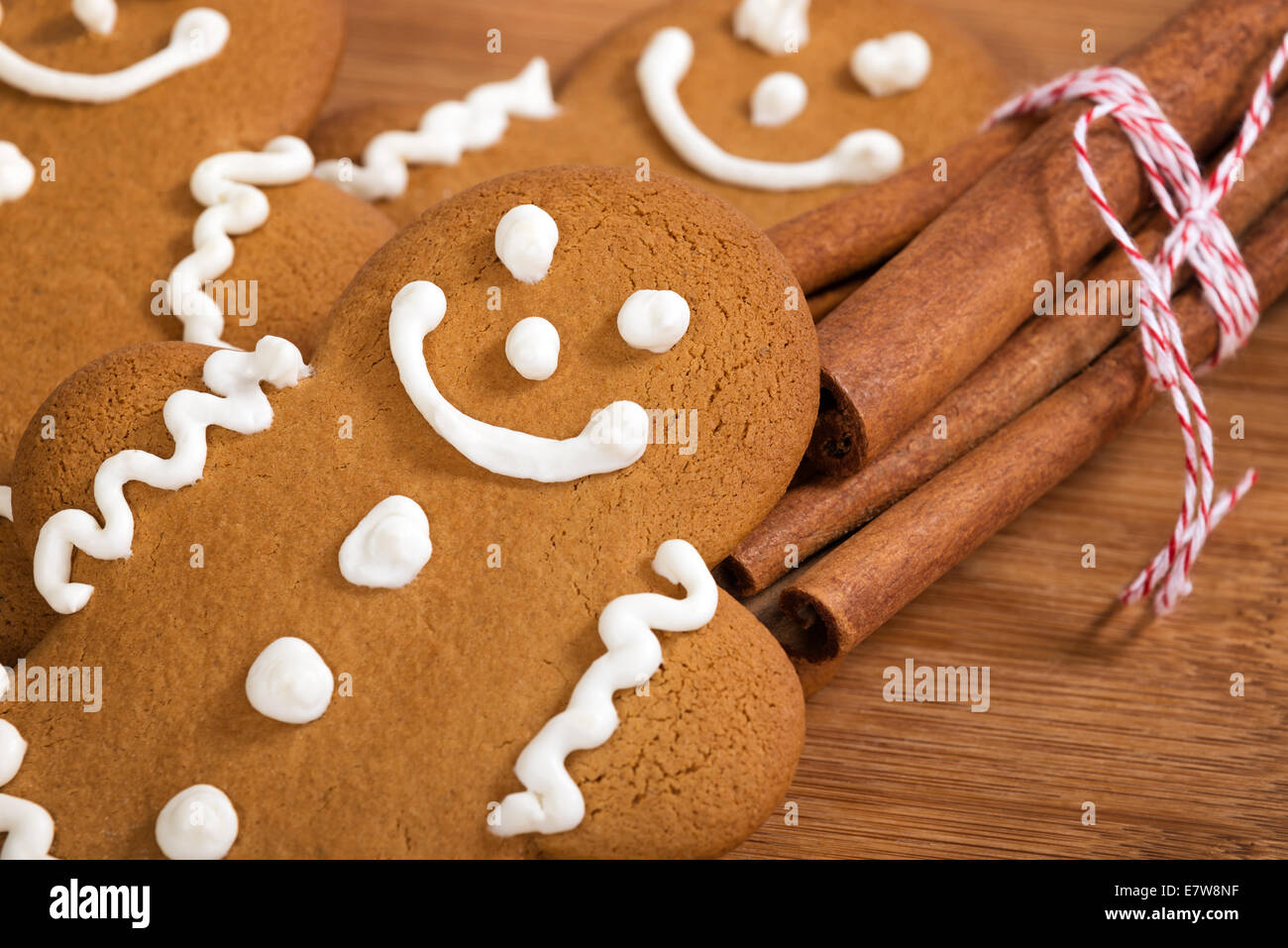 Des petits gingerbread man cookies avec des bâtons de cannelle sur planche à découper en bois Banque D'Images