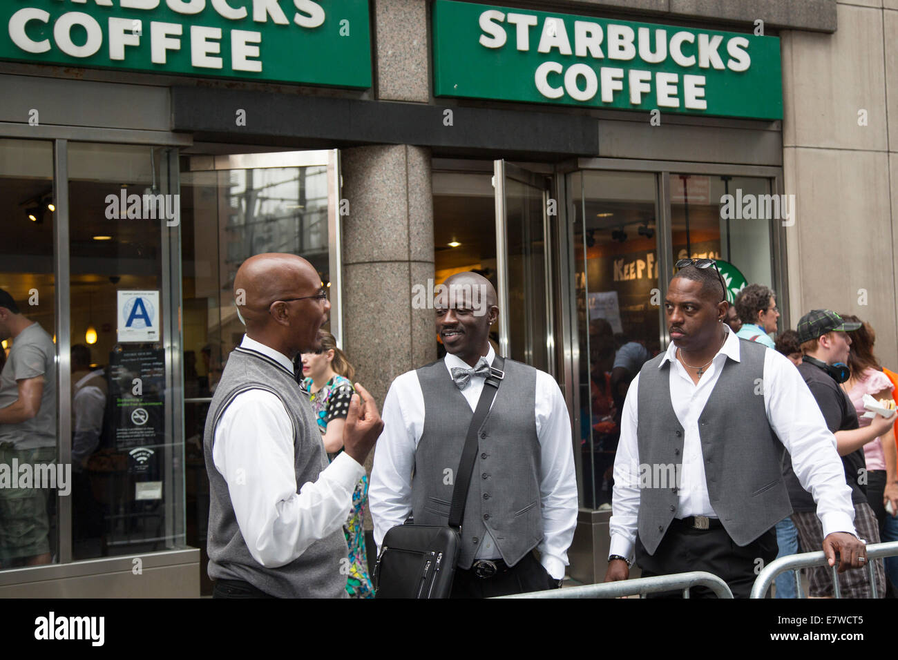New York, New York - les hommes afro-américains à l'extérieur de la tenue d'affaires un Starbucks sur la 42e Rue. Banque D'Images