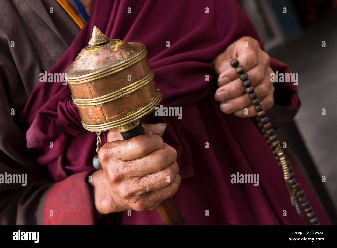 L'est du Bhoutan, Monastère, Trashigang Rangjung mains de vieux moine avec prières et perles Banque D'Images