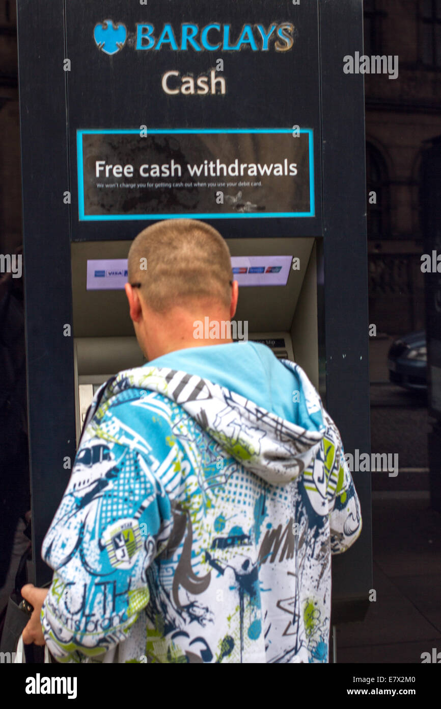 Un homme à l'aide d'un distributeur automatique de billets à Sheffield UK Banque D'Images