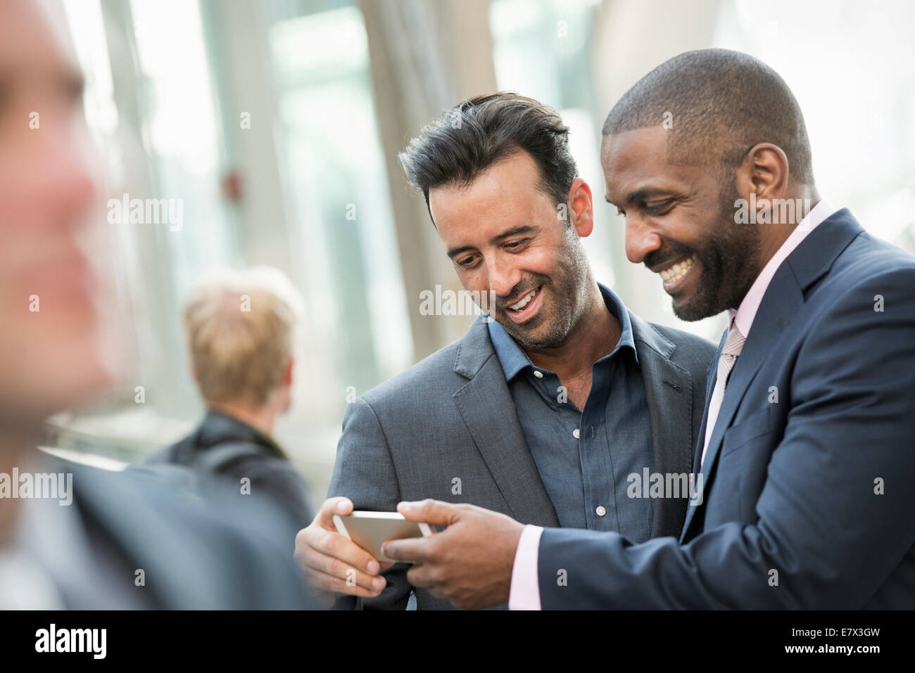Deux hommes la vérification d'un téléphone intelligent. Banque D'Images