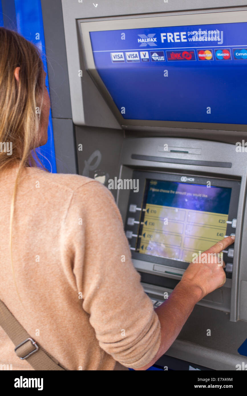 Une jeune femme d'un distributeur de billets ATM Halifax Banque D'Images