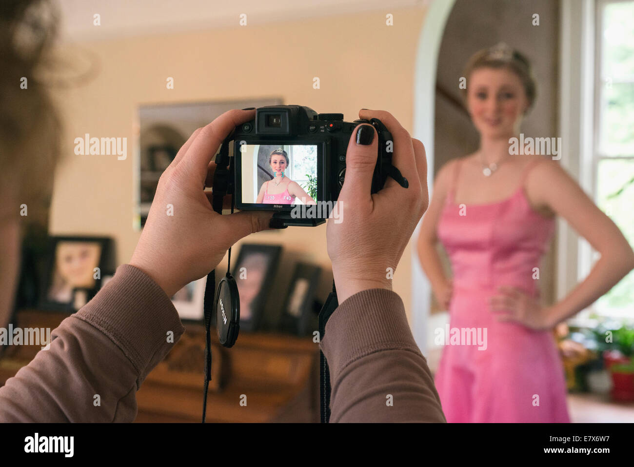 Une mère de prendre une photo de sa fille dans une robe de bal. Banque D'Images