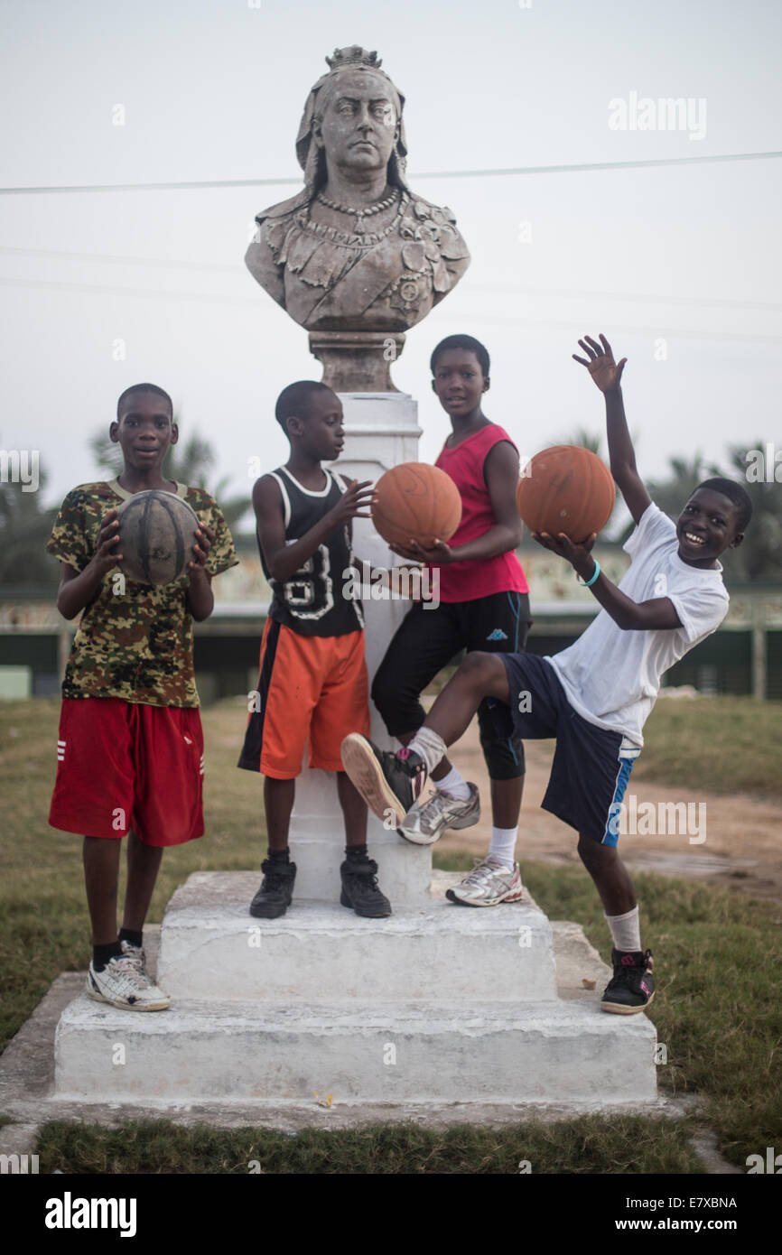 Les enfants jouent au basket-ball autour d'une statue de la reine victoria Banque D'Images