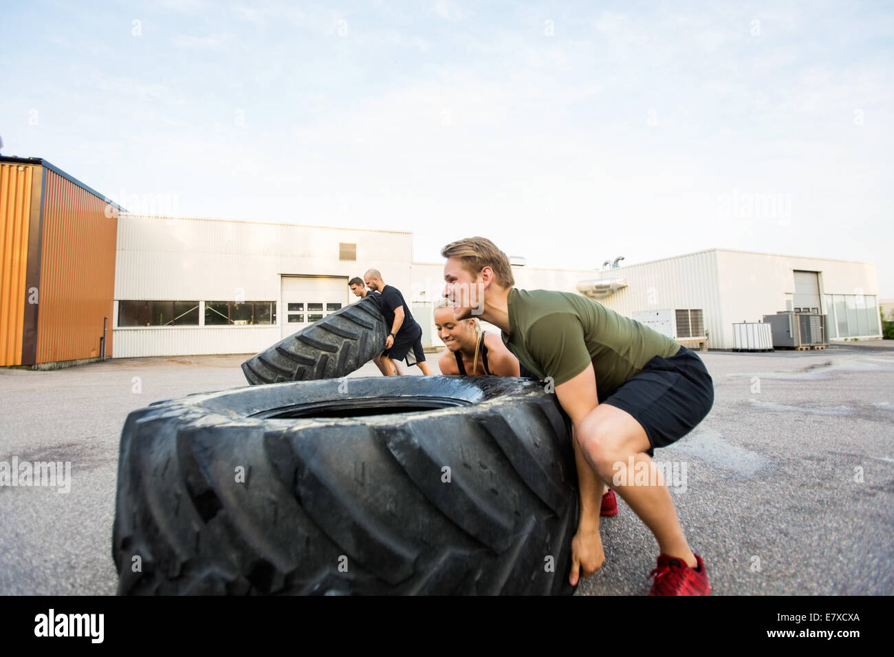 Mettre en place les athlètes faisant tire-flip exercice Banque D'Images