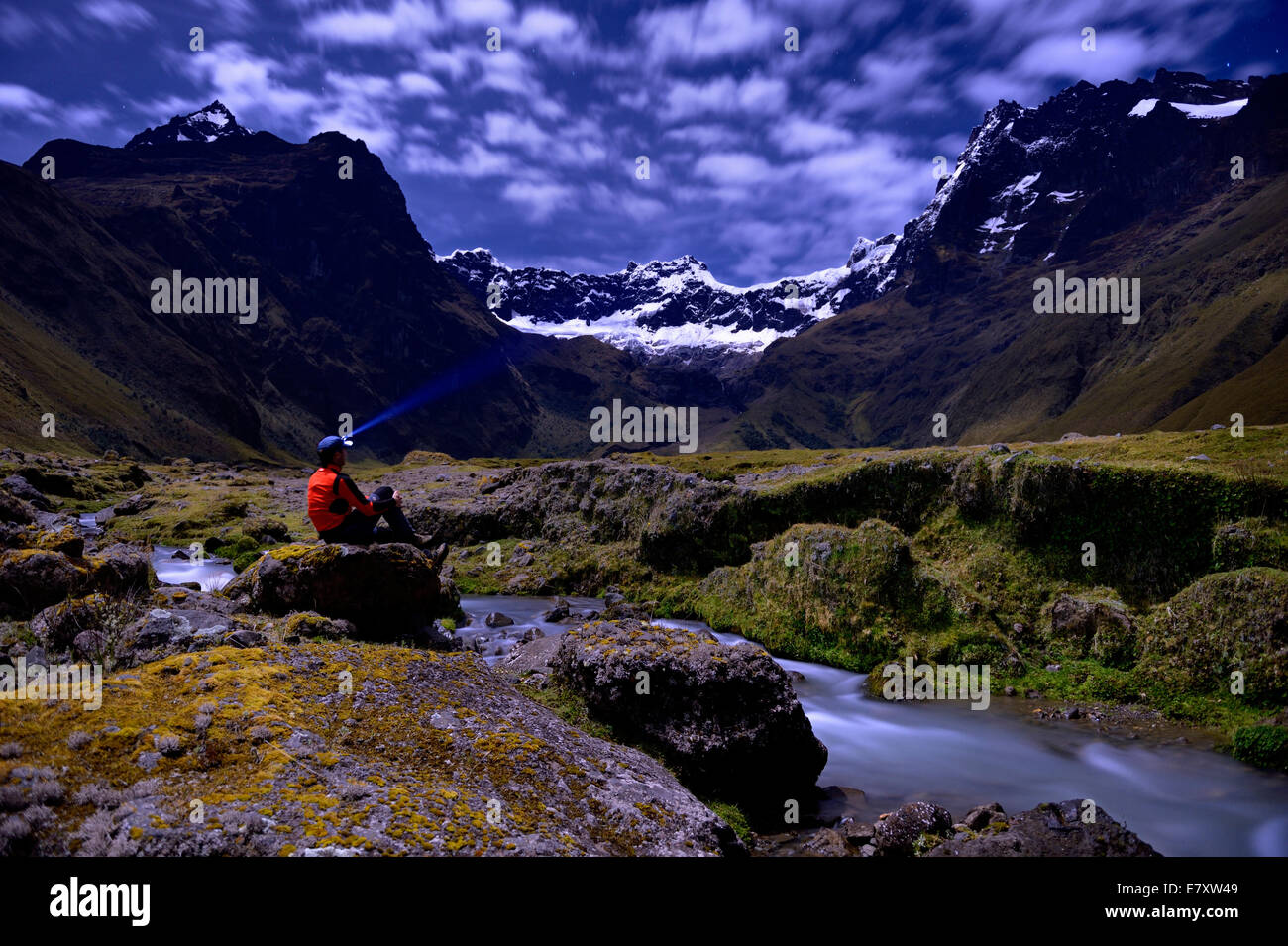 Mountaineer assis à un ruisseau de montagne aux pics de El Altar ou Kapak Urku, dans moonlight, Riobamba, Région Cotopaxi Banque D'Images