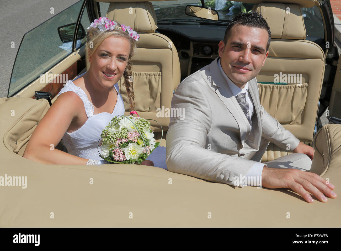 Bride and Groom posing sur le siège arrière d'une voiture ouverte, convertible Banque D'Images