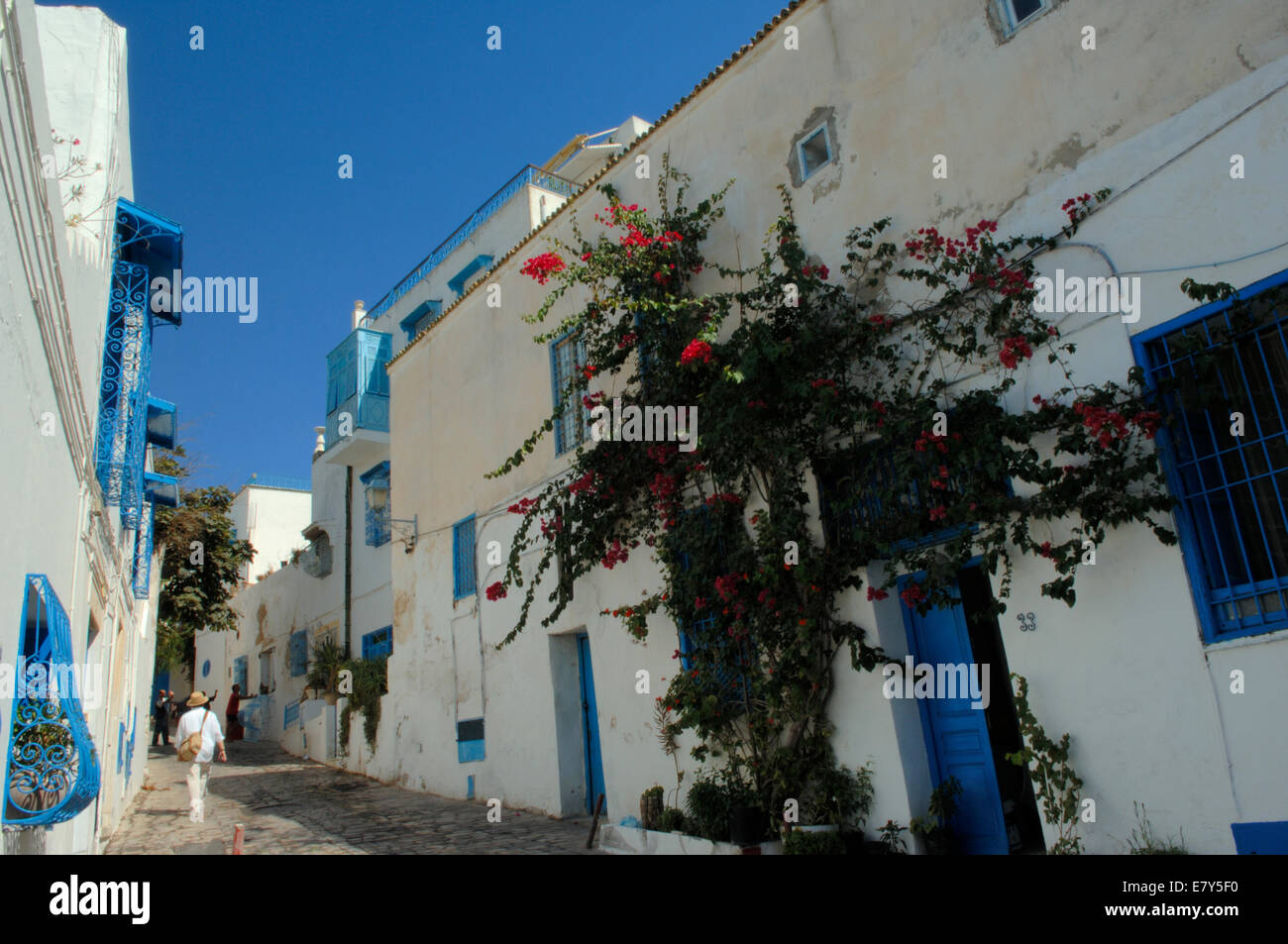 Une rue pavée, des bâtiments blanchis à la chaux avec fenêtre bleu des grillades dans la falaise village de Sidi Bou Saïd, Tunisie Banque D'Images