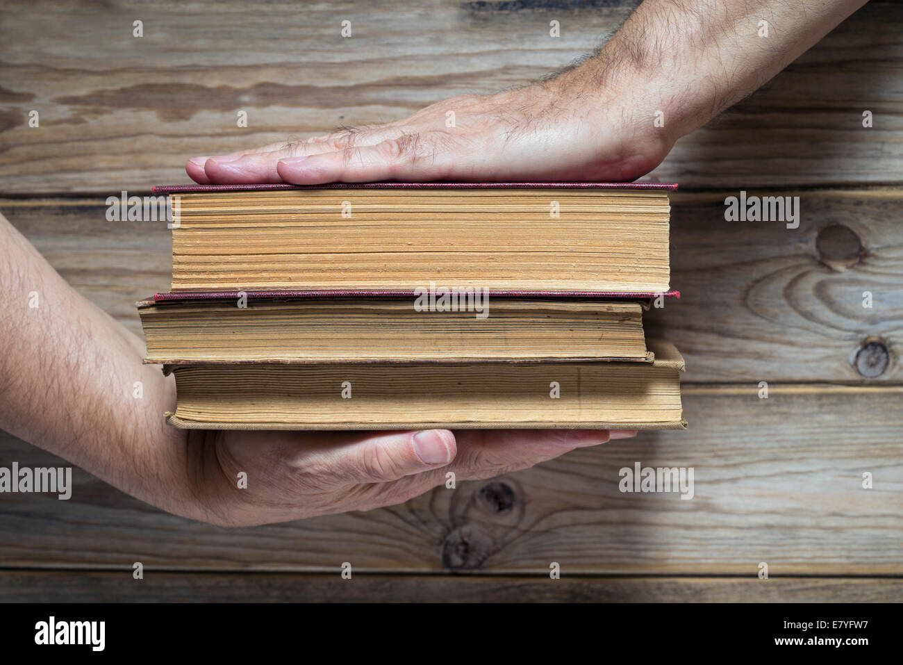 La main de l'homme tenir trois livres anciens Banque D'Images