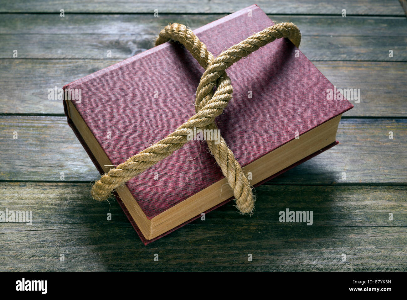 Vieux livre attachés avec une corde épaisse sur une table en bois Banque D'Images