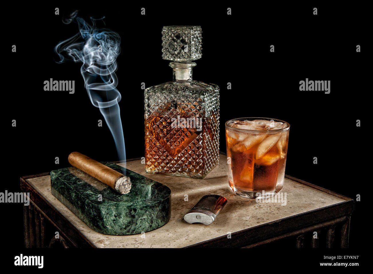 Fumer un cigare s'assoit à côté d'une carafe en cristal de l'alcool. Banque D'Images