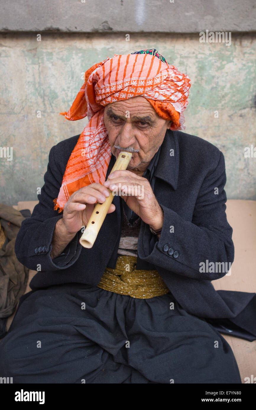 Un vendeur de rue portant des vêtements traditionnels vend du tabac et des flûtes à Erbil (Kurdistan iraquien, Arbil) province, l'Iraq. Banque D'Images