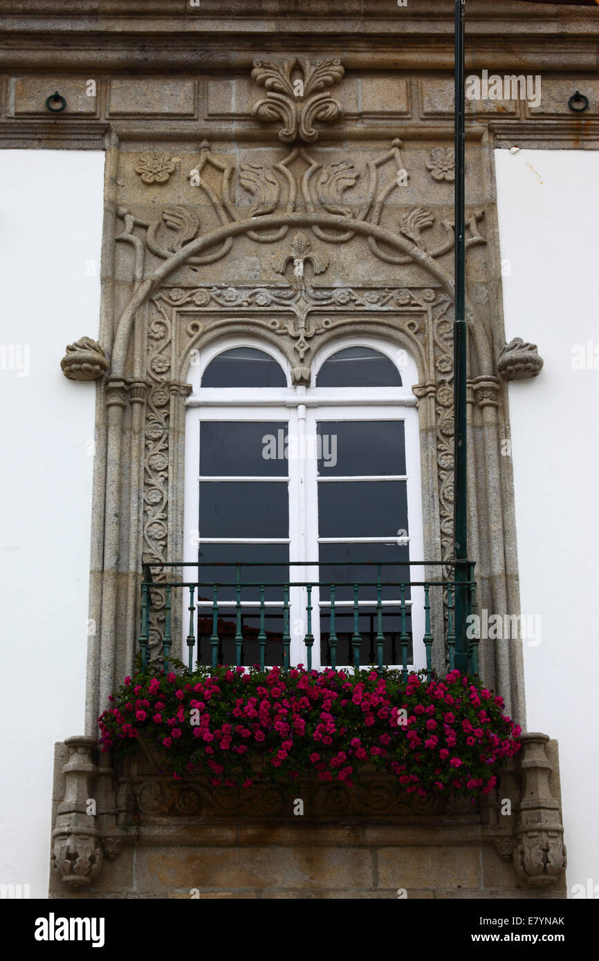Fenêtre en pierre sculptée ornée du manoir Casa de Carreira et géraniums dans la boîte de fenêtre, Viana do Castelo, nord du Portugal Banque D'Images