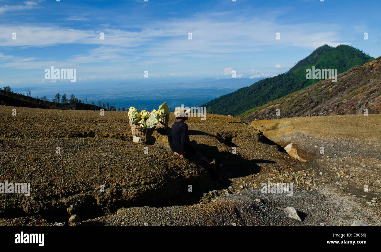 Miner de repos portant sa charge de soufre à l'volcan Kawah Ijen à Java Est, Indonésie Banque D'Images