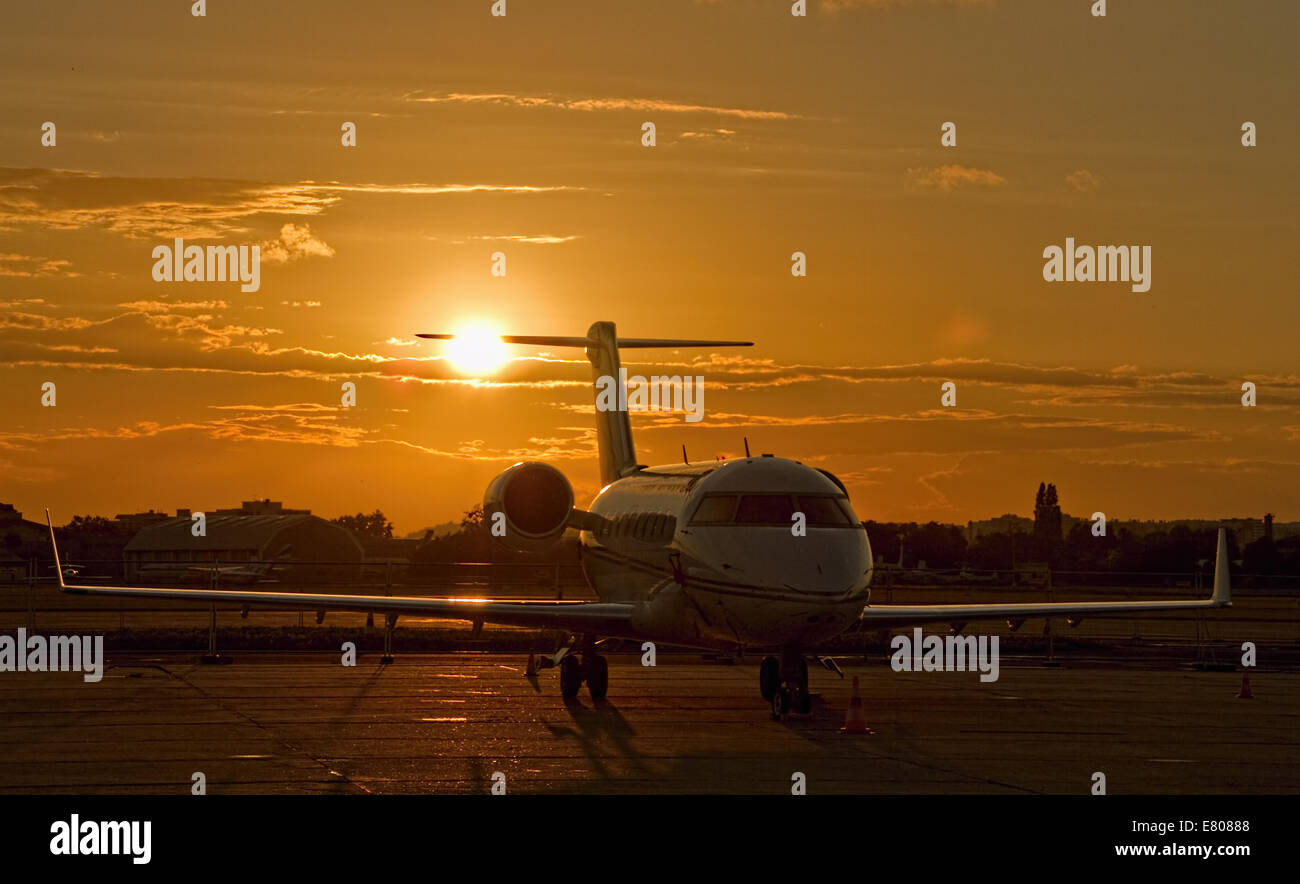 Soleil derrière corporate jet sur airfield Banque D'Images