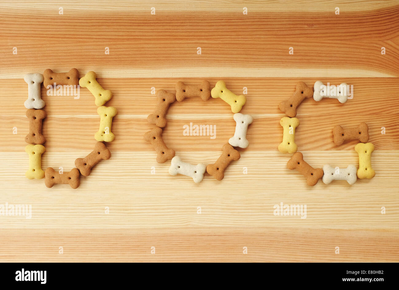 Le mot chien énoncés dans les biscuits pour chiens en forme d'os sur un fond de bois Banque D'Images