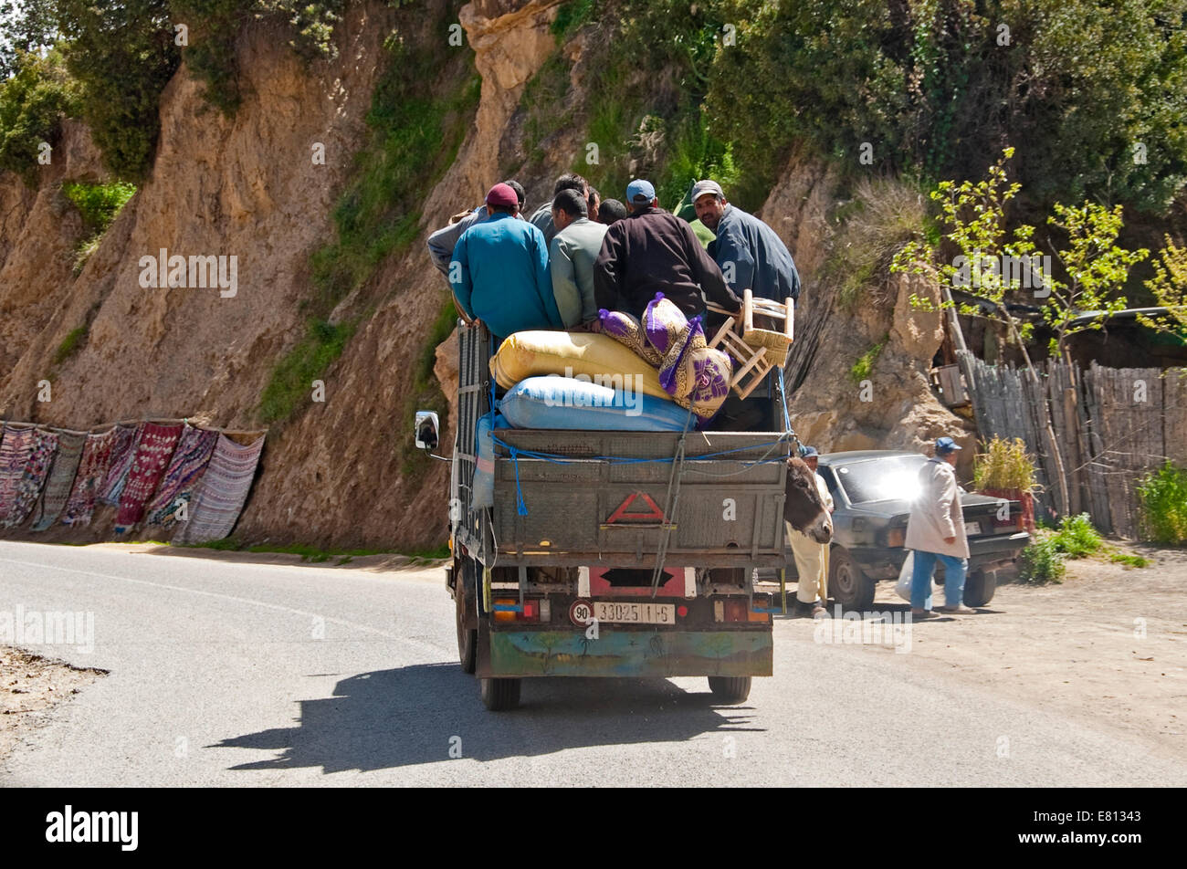 Vue horizontale d'un camion surchargé qui voyagent à travers la chaîne de montagnes du Haut Atlas au Maroc. Banque D'Images