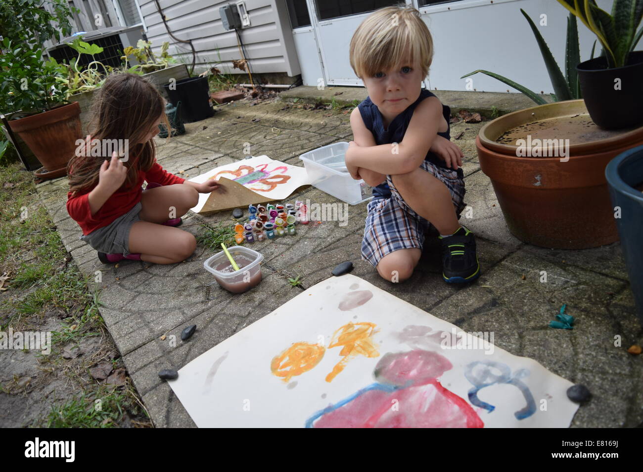 Boy and girl making art in backyard Banque D'Images