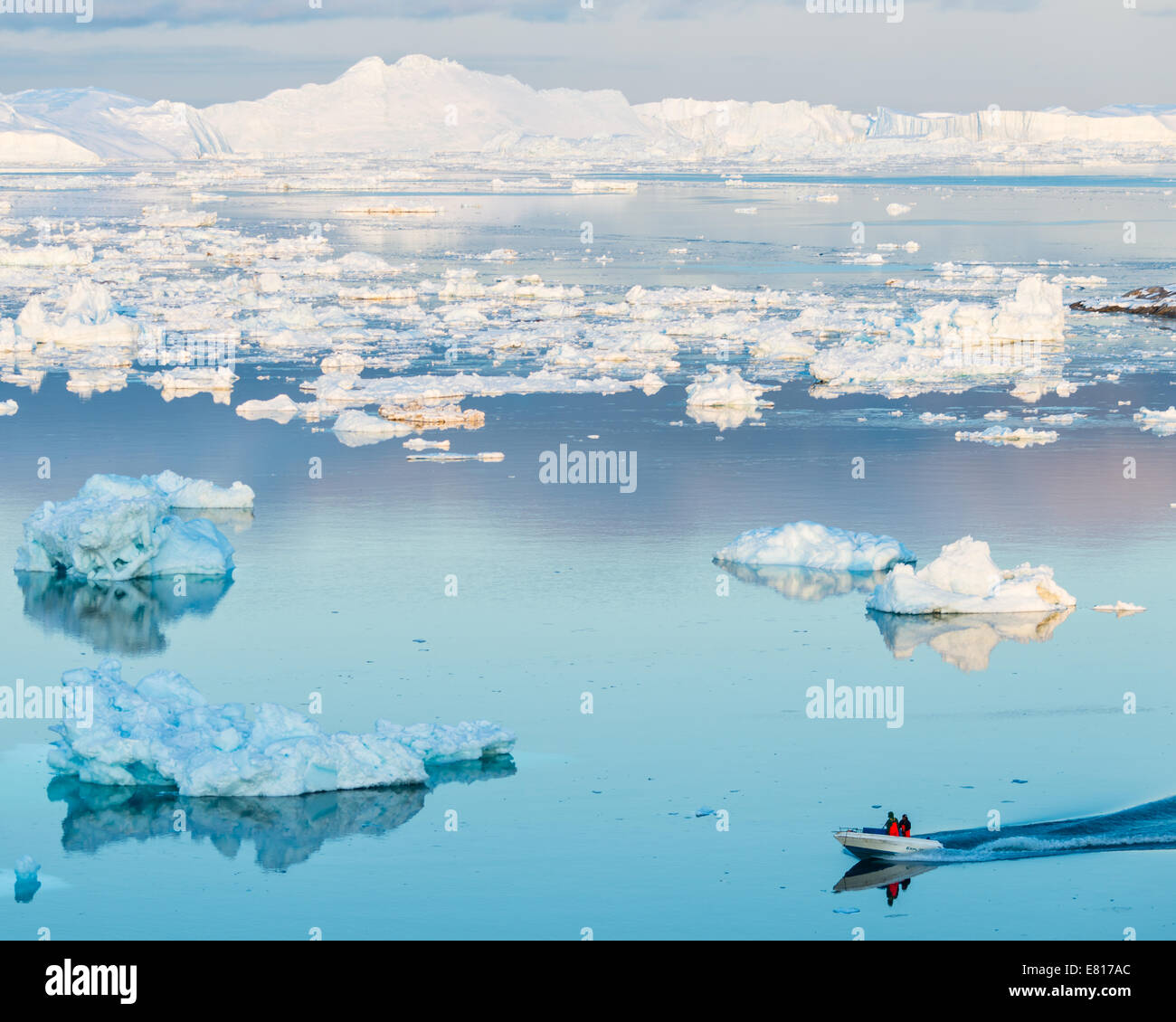 Deux personnes naviguer un bateau à travers les eaux du glacier-remplie Banque D'Images