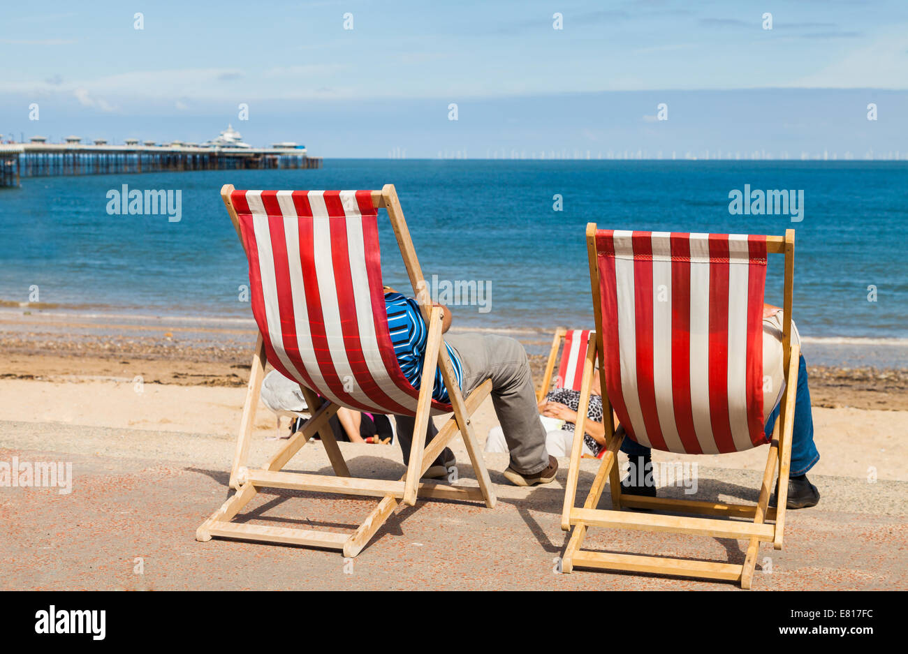 Des gens assis détendu sur un jour d'été dans un transat sur une station balnéaire face à la mer. De derrière Banque D'Images