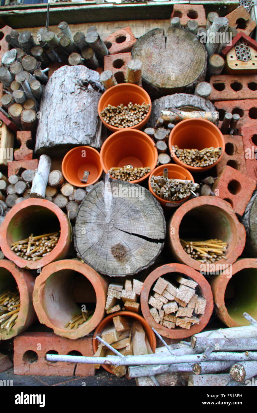 Détail d'un hôtel de la faune d'insectes (pile) avec des briques, bambou, les chaudrons et les journaux pour encourager l'hibernation des insectes dans des jardins, UK Banque D'Images