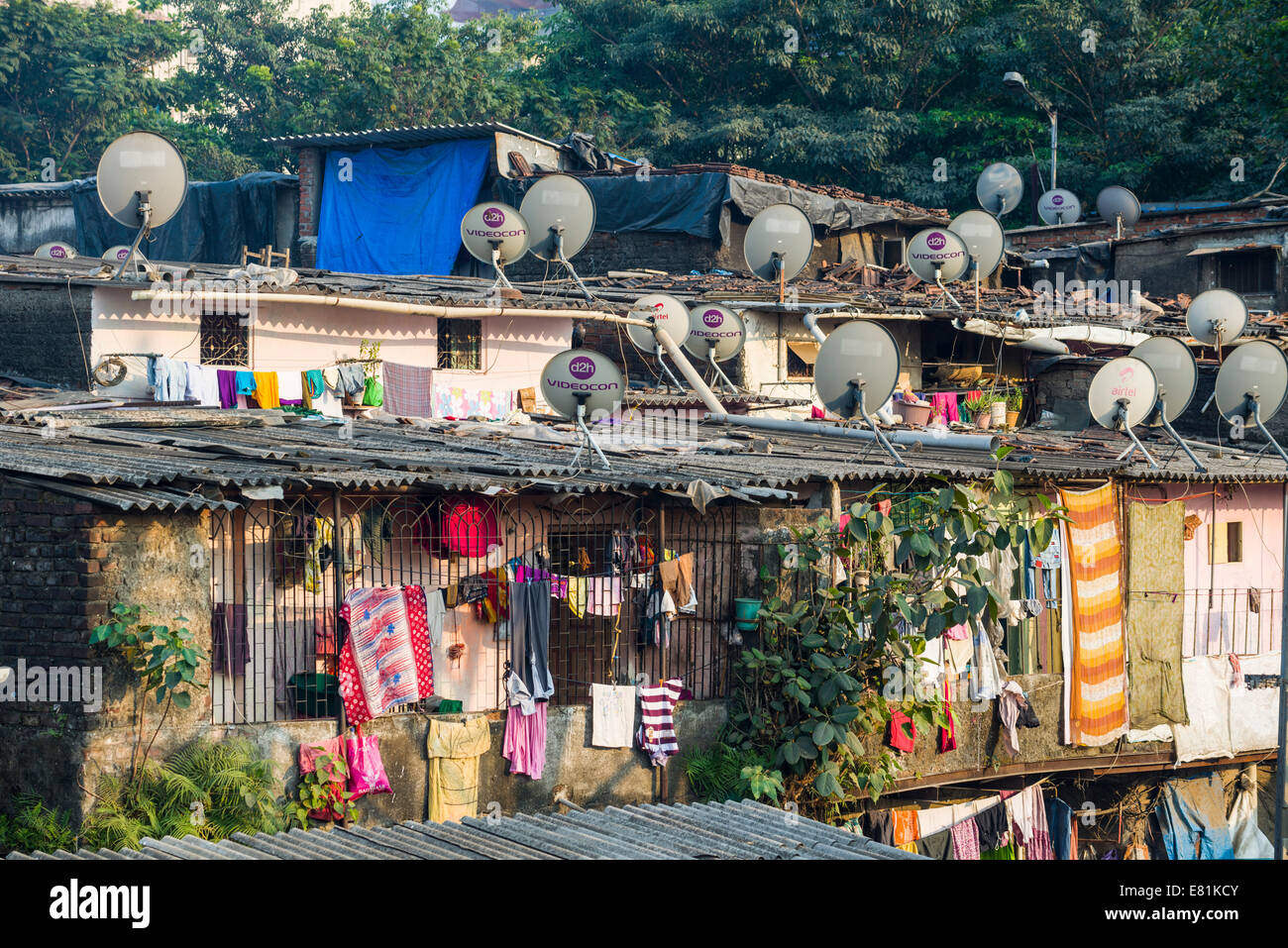 Un bidonville avec des maisons faites de tôle ondulée, avec des plats de télévision sur les toits, Mumbai, Maharashtra, Inde Banque D'Images