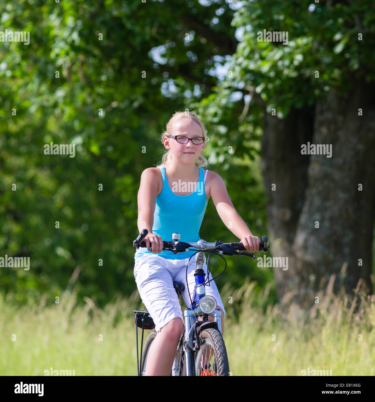 Girl riding bicycle on country lane Banque D'Images