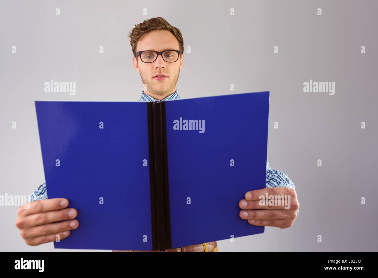 Geeky student reading a book Banque D'Images