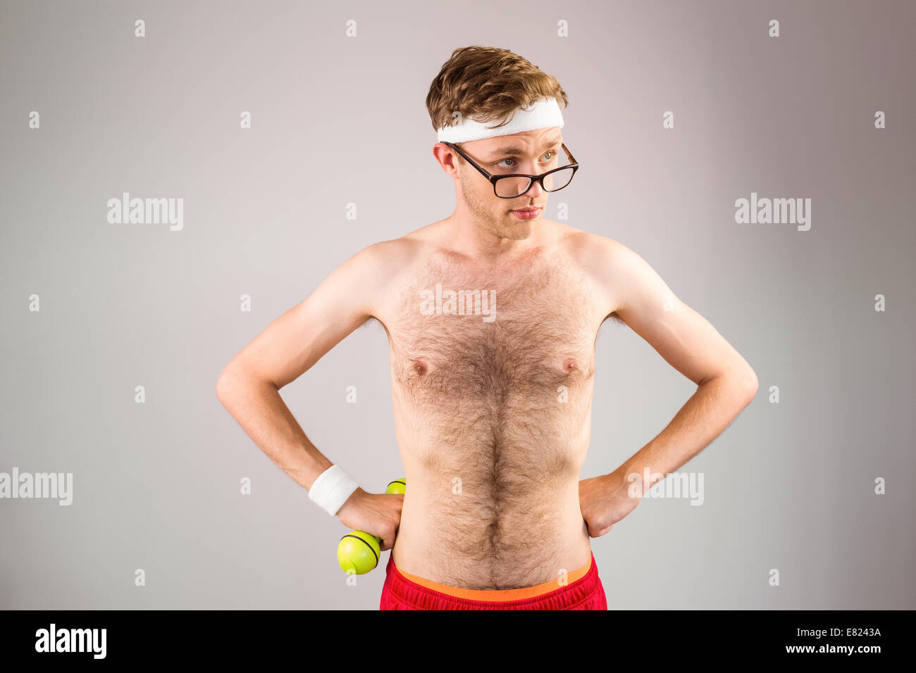 Geeky shirtless hipster posing with dumbbell Banque D'Images