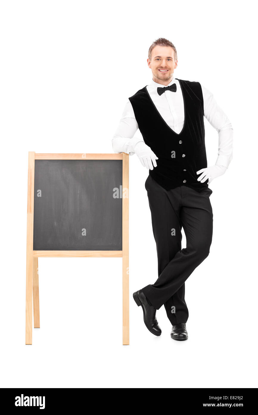 Full Length portrait of waiter debout à côté d'un tableau noir isolé sur fond blanc Banque D'Images