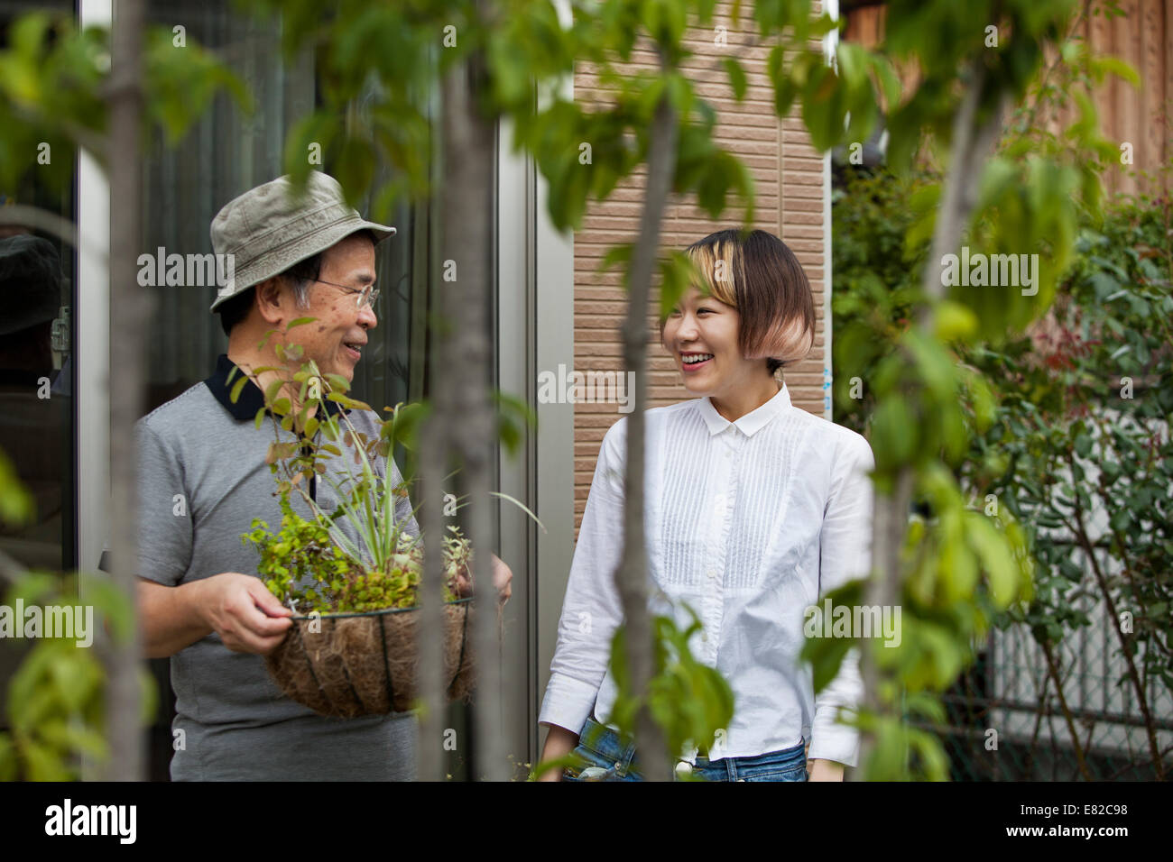 Un homme et une femme debout dans leur jardin. Banque D'Images