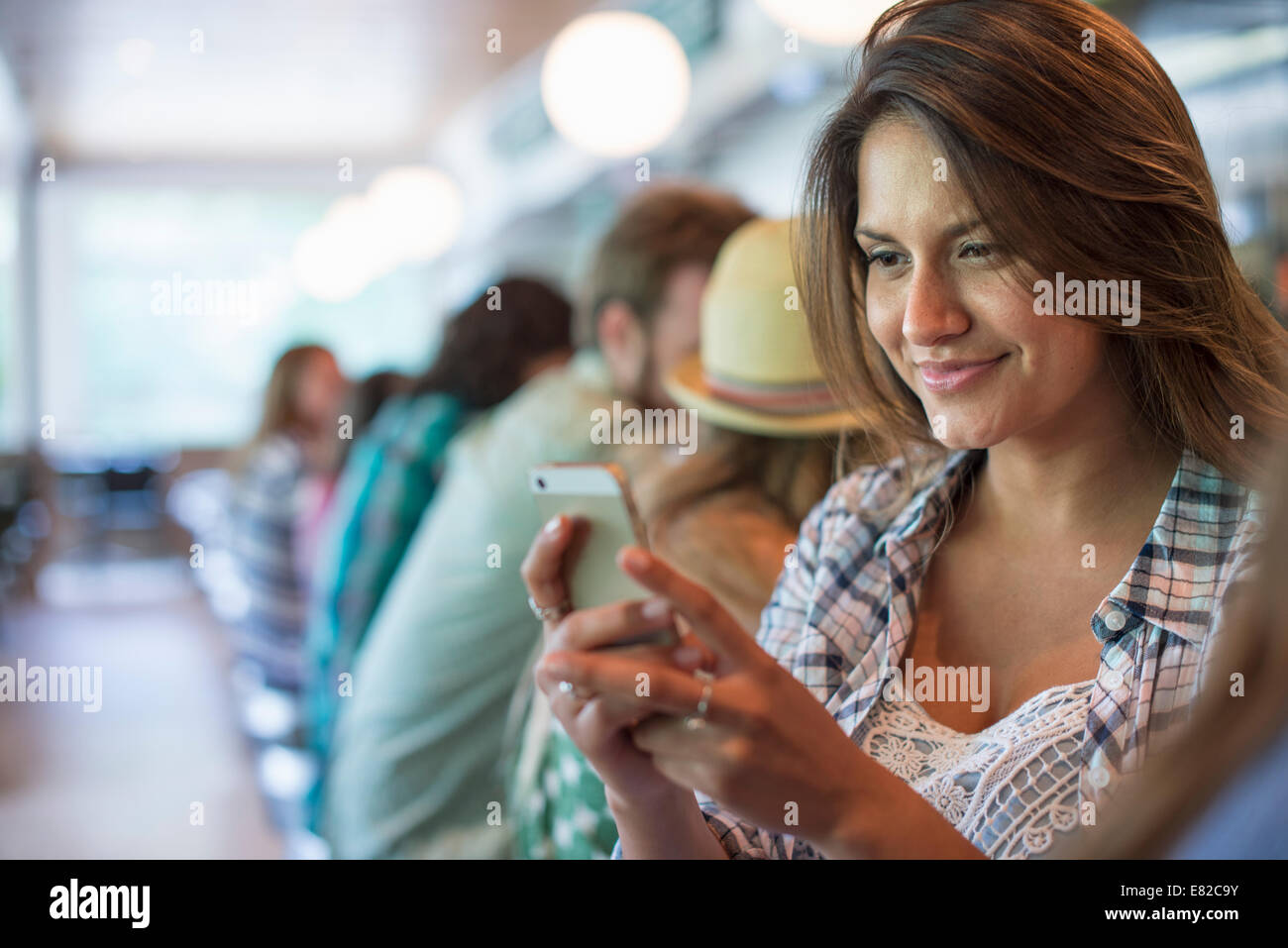 Une femme dans un diner, en regardant son téléphone portable. Banque D'Images Une femme dans un diner, en regardant son téléphone portable. Banque D'Images