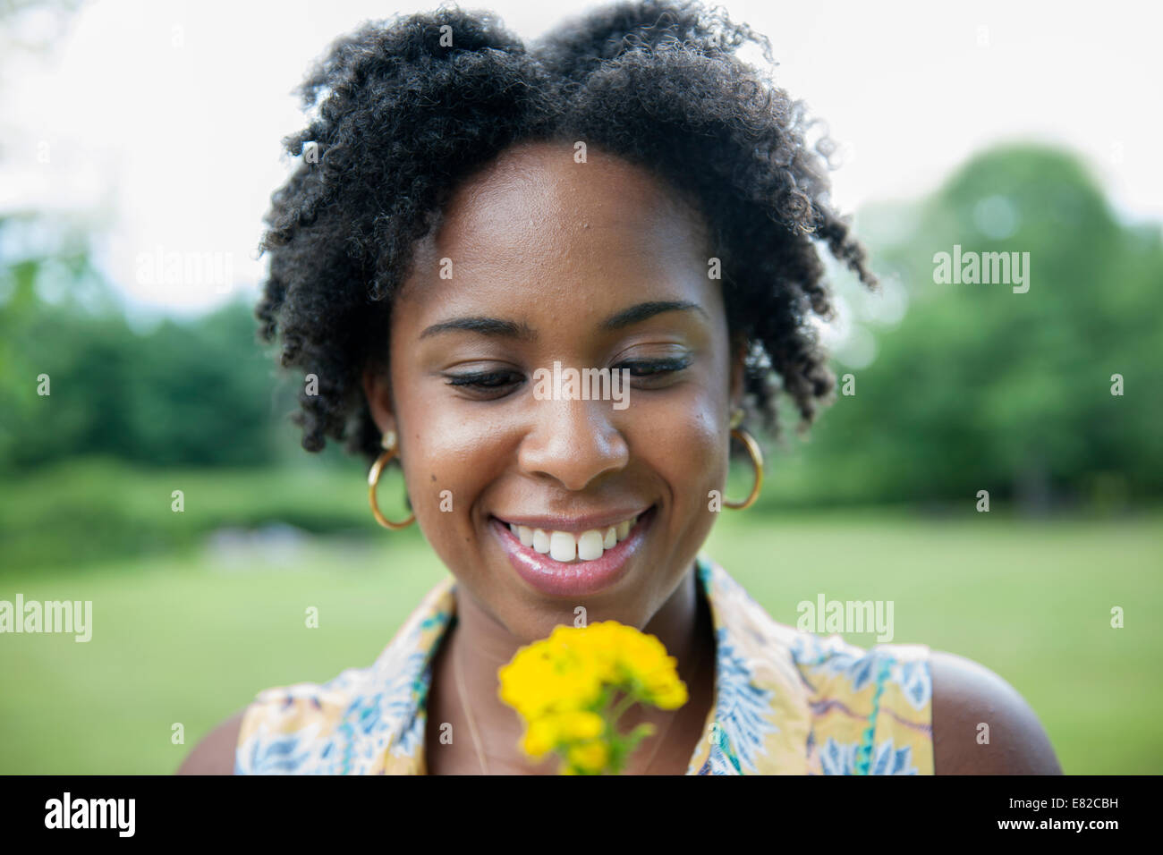 Portrait de femme tenant une fleur jaune. Banque D'Images